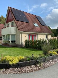 uma casa com painéis solares no telhado em Heerlijk genieten. em Hoogersmilde