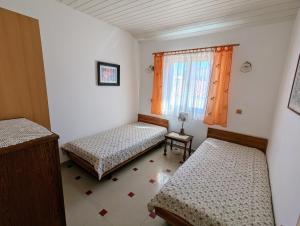 a small room with two beds and a window at Apartmani Petković in Zaboric