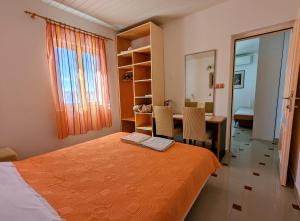 a bedroom with a bed and a desk and a table at Apartmani Petković in Zaboric