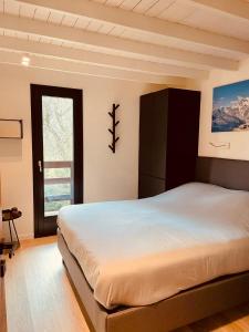 a bedroom with a large bed and a window at Superb Chalet Monterosa in Anzino