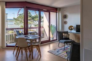 ein Wohnzimmer mit einem Tisch und Stühlen sowie einem Balkon in der Unterkunft LE DANVIN - Spacieux Studio 4 pers - Grand balcon - A 150 m de la Plage in Berck-sur-Mer