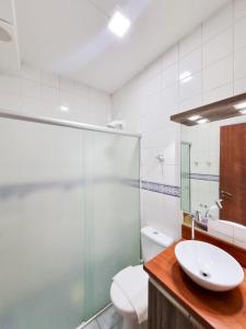 y baño con lavabo, aseo y espejo. en Apart Hotel Beira do Mar, en Florianópolis