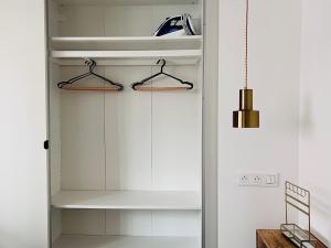 a closet with white cabinets and a pendant light at Montmartre Marvel! Renovated Workshop near the Sacré-Coeur Basilica in Paris