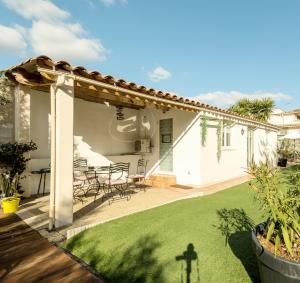 un patio avec une table et des chaises sous une pergola dans l'établissement Villa 3 Logements entiers avec piscine et jaccuzi et parking, à Marseille