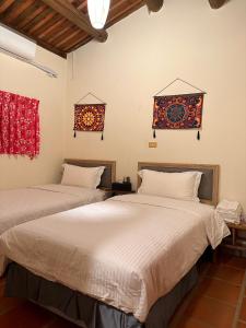 a bedroom with two beds and two windows at Yong Le Homestay in Jincheng