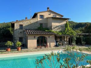 een huis met een zwembad ervoor bij Casa Batano in San Casciano dei Bagni