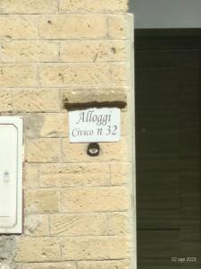 una señal de calle blanca en una pared de ladrillos en ALLOGGIO BLU nel CUORE DI SORIANO, en Soriano nel Cimino