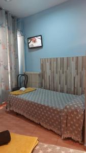 1 dormitorio con 1 cama en una habitación azul en Pension Suiza, en Reus
