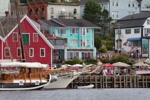 a boat docked at a dock in front of houses at Brigantine Inn in Lunenburg