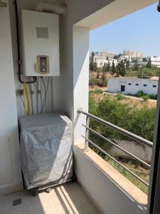 Zimmer mit Balkon und Blick auf ein Gebäude in der Unterkunft Appartement - Manar 1 Tunis in Tunis