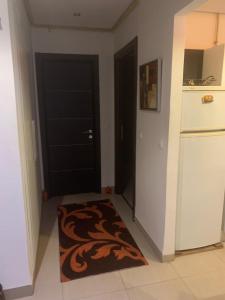 eine Küche mit einer schwarzen Tür und einem braunen Teppich in der Unterkunft Appartement - Manar 1 Tunis in Tunis