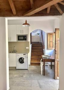 a kitchen with a washing machine and a table and a staircase at Casa Amaranto: tranquility and charming place in San Andres y Sauces