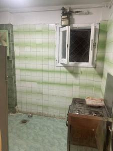 a kitchen with green tiled walls and a window at sea zone in Alexandria