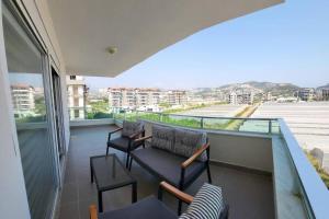 Un balcón con 2 sillas y un sofá. en 330qm Apartment in Alanya, 300m vom Meer, toller Ausblick, en Alanya