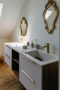 La salle de bains est pourvue d'un lavabo et d'un miroir. dans l'établissement LA VILLA COTTON - Superbe Villa avec Spa Face à la mer, à Plobannalec-Lesconil