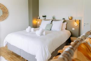 - une chambre avec 2 lits et des oreillers blancs dans l'établissement LA VILLA COTTON - Superbe Villa avec Spa Face à la mer, à Plobannalec-Lesconil
