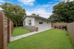 una casa con una valla y un patio en Peaceful Retreat By Pmi, en Fort Lauderdale