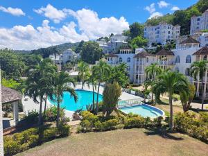 uma vista para um resort com uma piscina e palmeiras em Gem on the Hill Ocho Rios em Ocho Rios