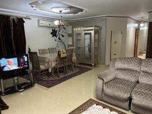 a living room with a couch and a dining room at Al Moayad Abbas Al Akkad Hotel in Cairo
