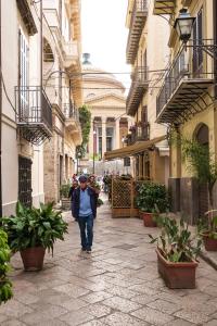 un hombre caminando por una calle en un callejón en B&B del Massimo, en Palermo