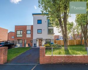 a white house with a fence and a driveway at Amazing Four Bed House At PureStay Short Lets & Serviced Accommodation Manchester Near Etihad With Parking in Manchester