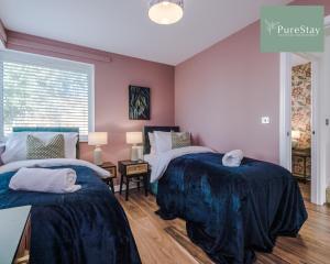 two beds in a bedroom with purple walls and wooden floors at Amazing Four Bed House At PureStay Short Lets & Serviced Accommodation Manchester Near Etihad With Parking in Manchester