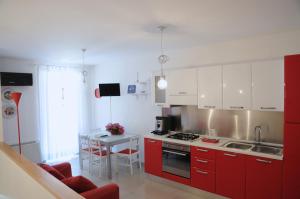 una cocina con armarios rojos y una mesa con fregadero en Ypsilhome, en Castelbuono
