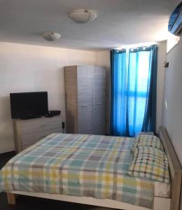 Dormitorio pequeño con cama y TV en SO Ionian Getaways, en Agios Gordios