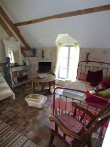 a living room with a bed and a table at Le Foulon - Moulin de Charme - 1 heure 30 de Paris in Saint-Hilaire-les-Andrésis