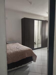 1 dormitorio con cama y espejo en casatemporada05, en Cabo Frío