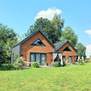 ein großes Holzhaus mit einem Grasfeld in der Unterkunft Eleonor Accommodation in Liszki