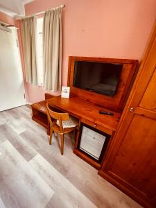 a living room with a television and a wooden table at Osteria-Hotel-Centovini in Cologne