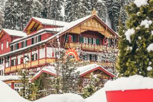 a large building in the snow with snow covered trees at Parkhotel Sole Paradiso in San Candido