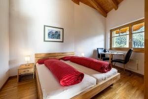 - une chambre avec un lit doté d'oreillers rouges dans l'établissement Trü-Sura Nr. 9, à Scuol