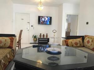 un salon avec une table basse en verre dans l'établissement Appartement Familial en face le grand stade de tanger, à Tanger