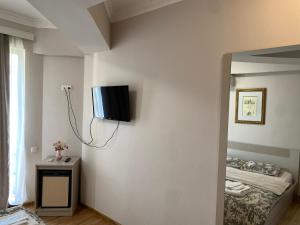 een kamer met een tv aan de muur en een bed bij Grand Central in Tskaltubo
