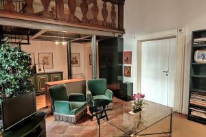 een woonkamer met 2 groene stoelen en een televisie bij Suite Patrimonio Unesco - Assisi Centro Storico in Assisi