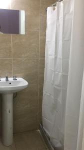 a bathroom with a sink and a shower curtain at Departamento monoambiente centro pb nuevo sencillo Av Belgrano D3 in Marcos Juárez