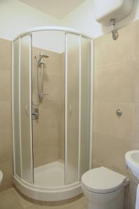 a bathroom with a shower with a toilet and a sink at Ypsilhome in Castelbuono