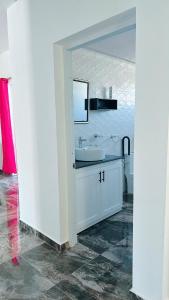 La salle de bains blanche est pourvue d'un lavabo et d'un miroir. dans l'établissement City suite Apartment 1 Cabrera, à Cabrera