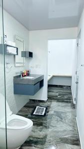La salle de bains blanche est pourvue de toilettes et d'un lavabo. dans l'établissement City suite Apartment 1 Cabrera, à Cabrera