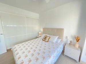 Un dormitorio blanco con una cama y una mesita de noche. en Summer`s Dream, en Benalmádena