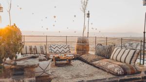 una sala de estar con sofás y una mesa en el balcón en La maison de Şişik, en Uchisar