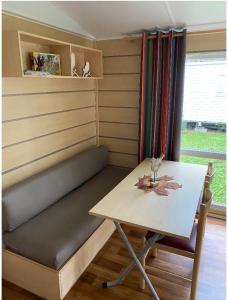 a bench and a table in a room with a table and chair at Mobile home proche de EUROPA PARK in Boofzheim