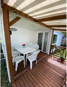 a white table and chairs on a wooden deck at Mobile home proche de EUROPA PARK in Boofzheim