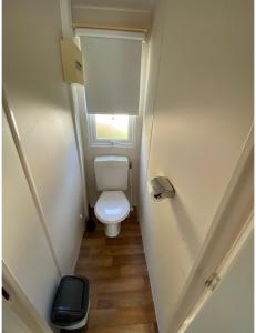 a small bathroom with a toilet and a window at Mobile home proche de EUROPA PARK in Boofzheim