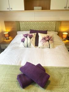 a bed with purple towels on top of it at Pottsville Cabin - 2 bed - near Praa Sands Beach in Praa Sands