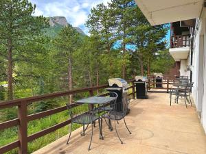 a patio with tables and chairs on a balcony at Fawn Valley Inn- 106 condo in Estes Park
