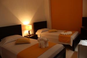 um quarto de hotel com duas camas e toalhas em Hotel Arcadia Colonial em Popayán