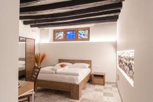 LA CURT guest house في Artogne: غرفة نوم بسرير ومكتب ونوافذ